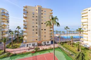 un edificio de apartamentos con pista de tenis y el océano en Apartment in Algarrobo Costa en Algarrobo-Costa