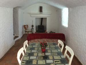 ein Esszimmer mit einem Tisch, Stühlen und einem Kamin in der Unterkunft Cuevas del Cipres in Baza