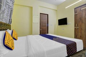 een slaapkamer met een bed en een tv aan de muur bij OYO Flagship Trinity Inn in Korādih