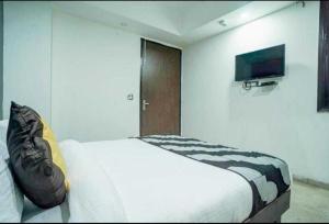 POP Hotel Pingal Dream Near Prachin Shani Mandir Near Dashrath Puri Metro Station tesisinde bir odada yatak veya yataklar