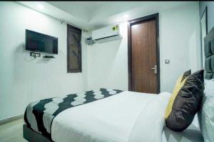 a bedroom with a bed and a television in it at POP Hotel Pingal Dream Near Prachin Shani Mandir Near Dashrath Puri Metro Station in New Delhi