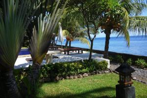 a view of the ocean from a resort with palm trees at Alam Mimpi Bali in Tejakula