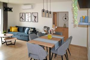 sala de estar con sofá azul, mesa y sillas en Sweet Retreat en Paralimni