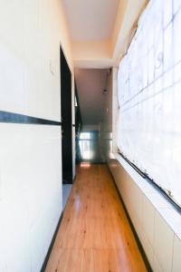 an empty hallway with a door and a wooden floor at OYO Hotel Honey House in Mahabaleshwar