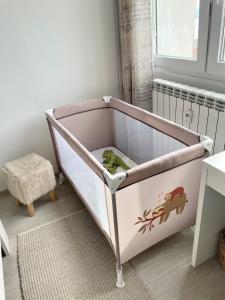a baby crib in a room with a bed at Adria Sky in Rijeka