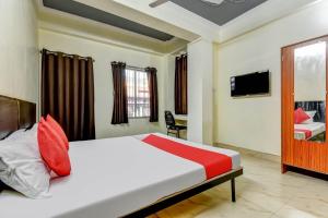 um quarto de hotel com uma cama e uma televisão em Super OYO Olive Grand em Patna