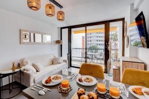 a living room with a couch and a table with food on it at Sea Cocoon in Playa de las Americas