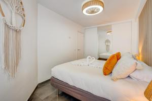 a bedroom with a bed with white sheets and orange pillows at Sea Cocoon in Playa de las Americas +7 photos