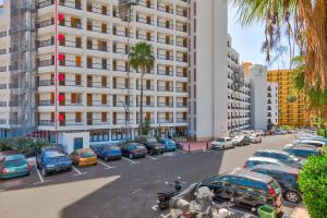 un parking avec des voitures garées devant un bâtiment dans l'établissement Sea Cocoon, à Playa de las Americas