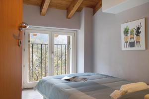 a bedroom with a bed and a large window at Il sole di calde Lago Maggiore 505 in Castelveccana