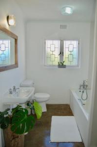 ein Bad mit einem Waschbecken, einem WC und einem Fenster in der Unterkunft Sagelands for business travel & family getaways in Durban