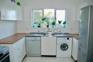 a kitchen with a washing machine and a sink at Sagelands for business travel & family getaways in Durban