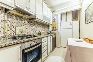 a kitchen with white cabinets and a stove top oven at Modern Flat with Balcony in Uskudar in Istanbul