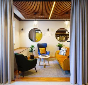 a living room with a yellow couch and blue chairs at Résidence services seniors CAZAM Pontoise in Pontoise