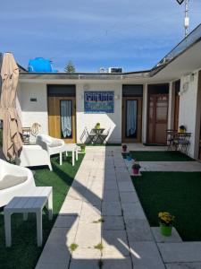 a patio with white furniture on the grass at Truly Apulia in Bari