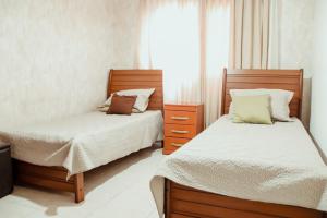 a bedroom with two beds and a window at Ed. Golden palace in Guarapari