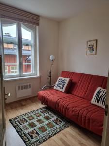 um sofá vermelho numa sala de estar com uma janela em Villa OLD POST em Juodkrantė