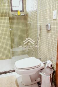 a bathroom with a toilet and a shower at Ed. Golden palace in Guarapari