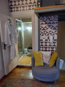 a living room with a blue chair and a bathroom at Mastixi in Chios