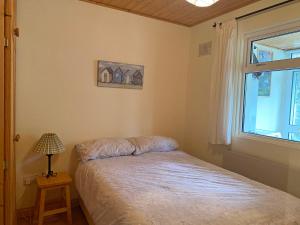 a small bedroom with a bed and a window at Apartment 235 Roundstone in Roundstone