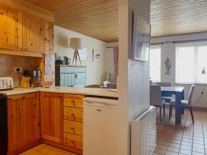 a kitchen with wooden cabinets and a table with chairs at Apartment 235 Roundstone in Roundstone