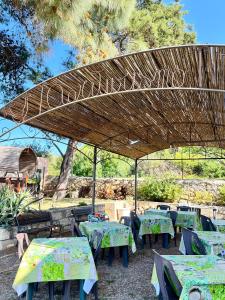 een picknickplaats met tafels en een houten parasol bij Agriturismo Silis in Sennori