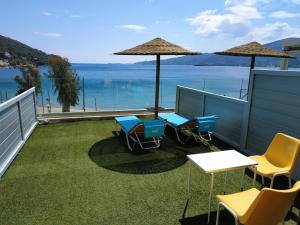 un patio con mesa y sillas y vistas al océano en New Aegli Resort Hotel, en Poros