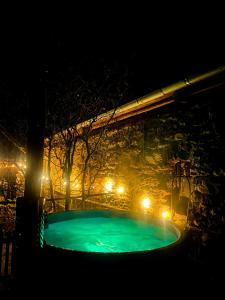 uma piscina à noite com luzes em Hybský dom em Hyby