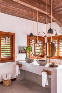 a bathroom with two sinks and wooden ceilings at Pousada Hayo Pé na Areia in Caraíva