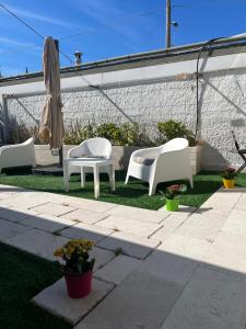 a patio with three chairs and a table and an umbrella at Truly Apulia in Bari