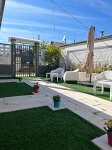 a patio with chairs and an umbrella on the grass at Truly Apulia in Bari