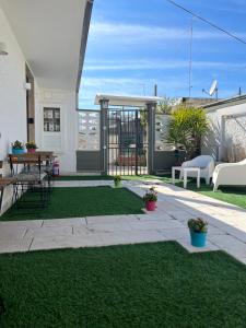 einen Hinterhof mit einer Terrasse mit einem Rasenhof in der Unterkunft Truly Apulia in Bari