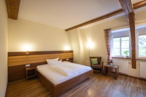 a bedroom with a bed and a chair and a window at Altstadthof Freinsheim in Freinsheim