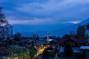 una pequeña ciudad de noche con una torre de reloj en Zostel Srinagar en Srinagar