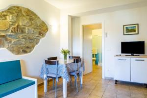 Un comedor con mesa y sillas y un televisor. en Casa Flavia - Castiglione, en Castiglione della Pescaia
