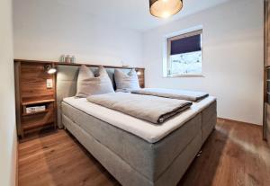 a bedroom with a large bed with a headboard at Ferienwohnung Alpenglück hoch3 in Oy-Mittelberg