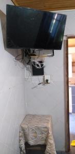 a flat screen tv hanging on a wall with a stool at La Chiqui - Quinta - Alquiler Temporario in Formosa