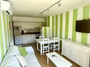 ALMA BEACH ESTARTIT في لو ايسترتيت: غرفة معيشة مع أريكة ومطبخ
