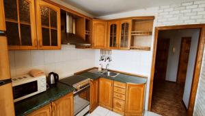 cocina con armarios de madera y encimera en KyivStay Vvedenska Apartment, en Kiev