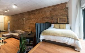 um quarto com uma cama e uma parede de tijolos em STUNNING Old Port lofts em Montreal