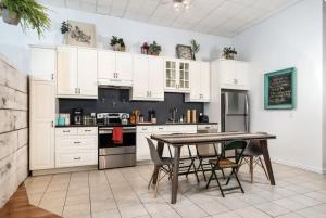 a kitchen with white cabinets and a table with chairs at STUNNING Old Port lofts in Montreal