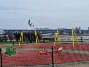 un parco giochi con altalene gialle su un campo da tennis di Apartament Nad Wisłą a Tczew