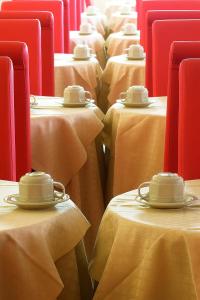 a table topped with red and white plates filled with food at Hotel Capri in Bardolino