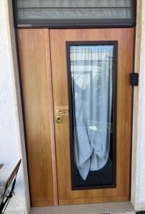 a wooden door with a window with a curtain at Truly Apulia in Bari
