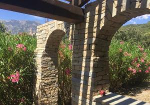 a brick bridge with pink flowers in the background at A Furtezza in Soveria