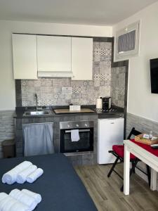 a kitchen with white cabinets and a table with towels at Truly Apulia in Bari