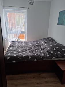 uma cama com um cobertor preto com estrelas em Apartament Nad Wisłą em Tczew