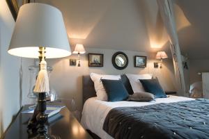 ein Schlafzimmer mit einem Bett und einem Tisch mit einer Lampe in der Unterkunft La Folie Saint Julien in Saint-Julien-de-Chédon