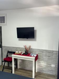 a living room with a table and a tv on a wall at Truly Apulia in Bari