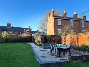 a garden with a table and chairs in front of a house at The Maltings in Shrewsbury